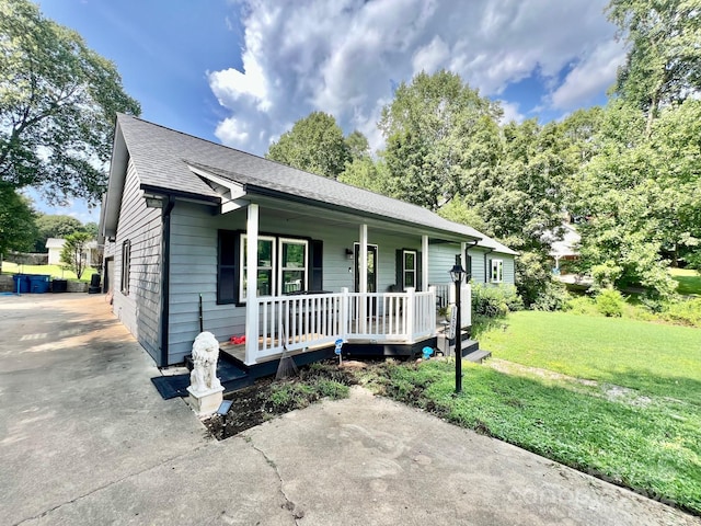 single story home featuring covered porch and a front lawn