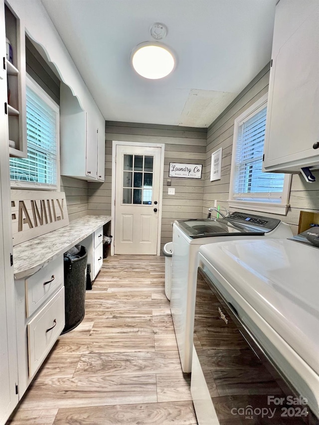 washroom with independent washer and dryer, light hardwood / wood-style flooring, cabinets, and wooden walls