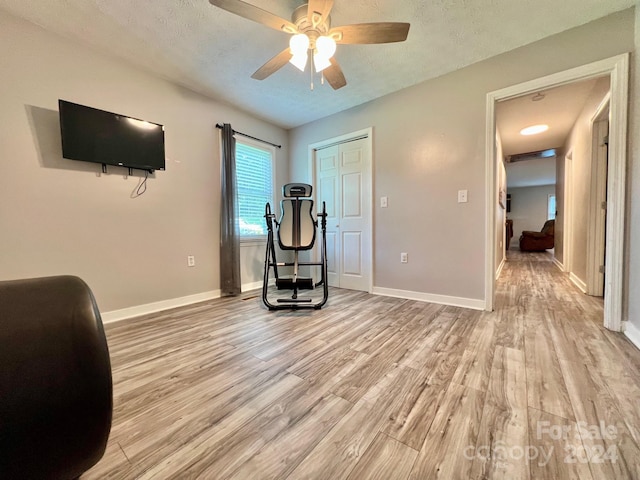 unfurnished office with ceiling fan, a textured ceiling, and light hardwood / wood-style floors