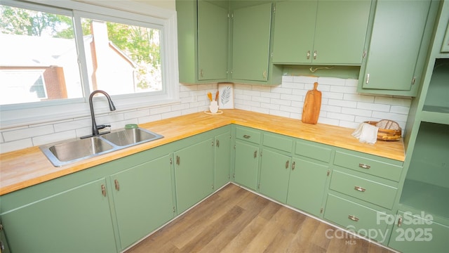 kitchen featuring green cabinetry, butcher block counters, and sink