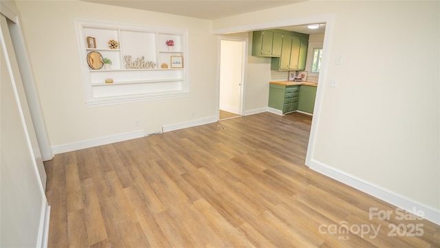 interior space featuring built in shelves and light hardwood / wood-style floors