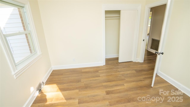 unfurnished bedroom with a closet and light hardwood / wood-style flooring