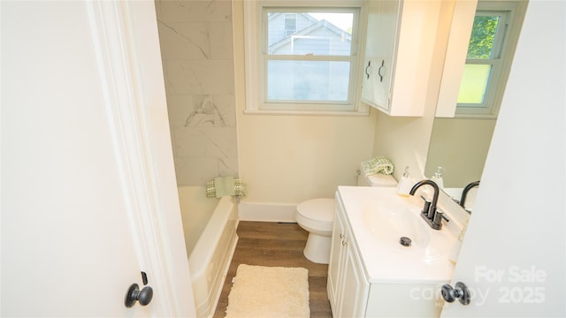 bathroom featuring a washtub, hardwood / wood-style floors, vanity, and toilet