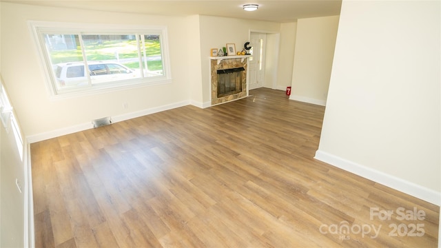 unfurnished living room with a fireplace and hardwood / wood-style floors