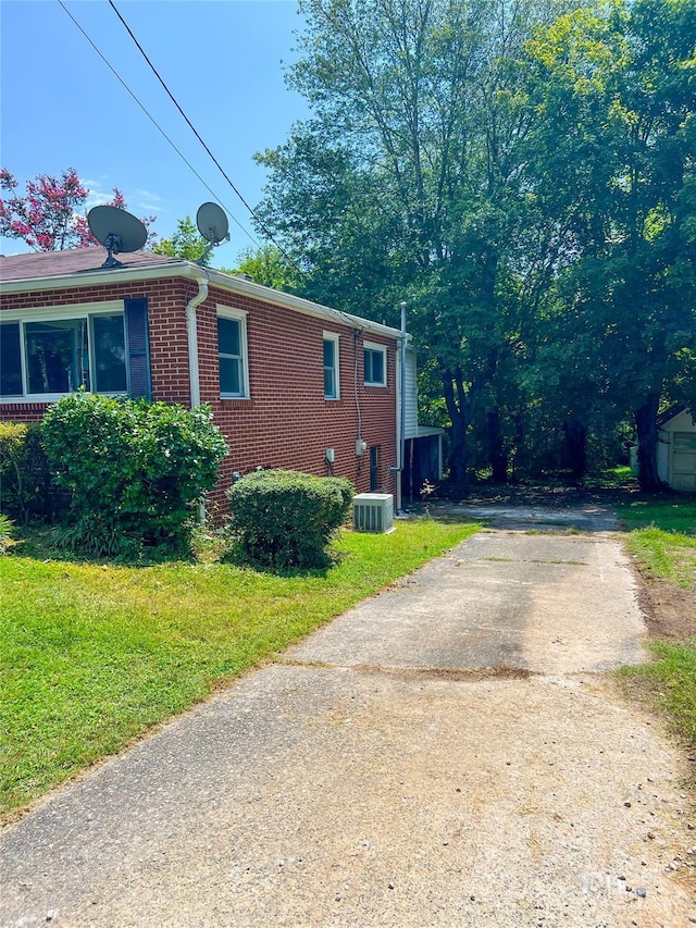 view of home's exterior with central AC unit and a yard