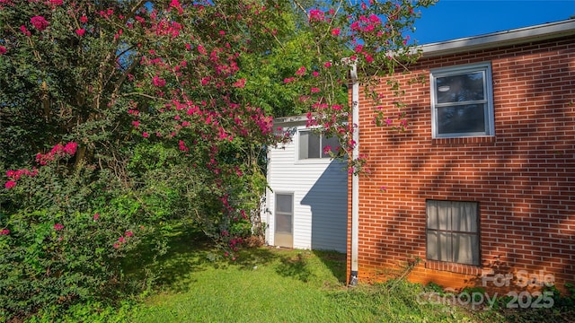 view of side of home with a yard