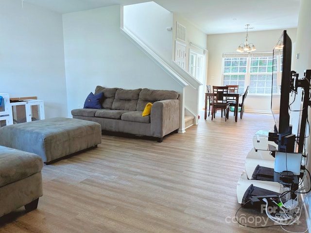 living room featuring an inviting chandelier and light wood-type flooring