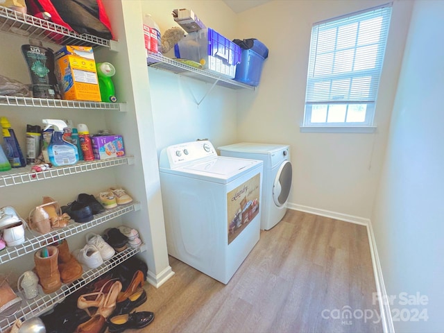 laundry room with light hardwood / wood-style floors and washing machine and dryer