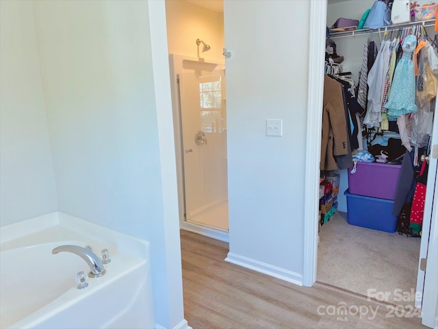 bathroom with hardwood / wood-style flooring and plus walk in shower