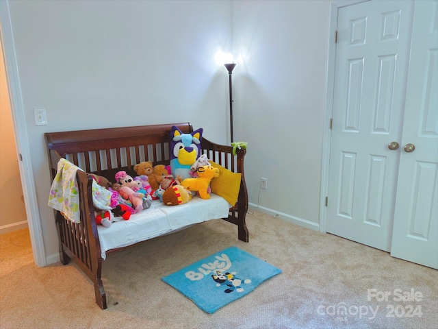 bedroom with light carpet and a nursery area