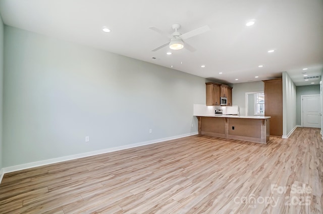 unfurnished living room with ceiling fan and light hardwood / wood-style floors