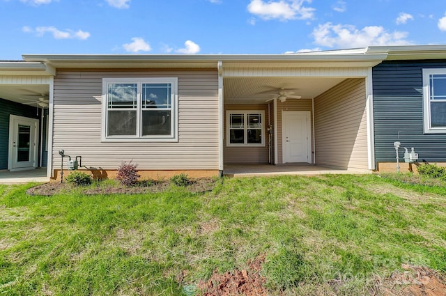 property entrance featuring ceiling fan, a patio area, and a lawn