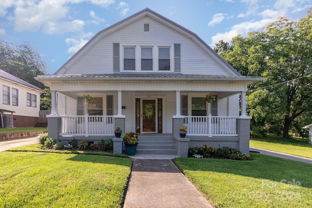 bungalow-style home featuring a front yard and covered porch