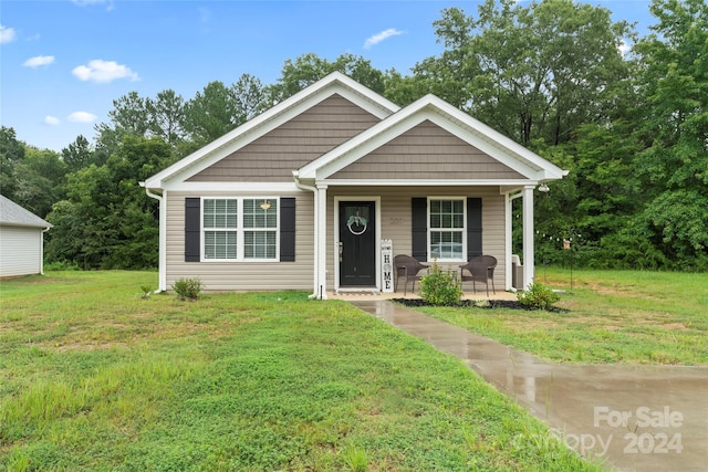 view of front of house featuring covered porch and a front yard