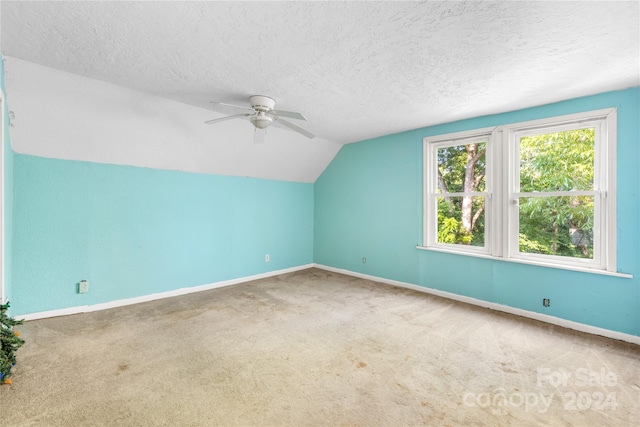 additional living space featuring carpet, a textured ceiling, ceiling fan, and vaulted ceiling