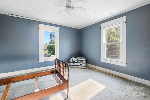 carpeted bedroom with ornamental molding and ceiling fan