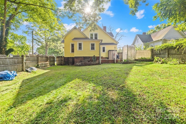 rear view of house featuring a yard