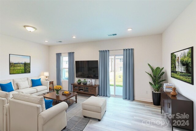 living room with a wealth of natural light and light hardwood / wood-style flooring