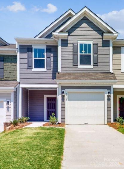 view of front of property with a front yard and a garage