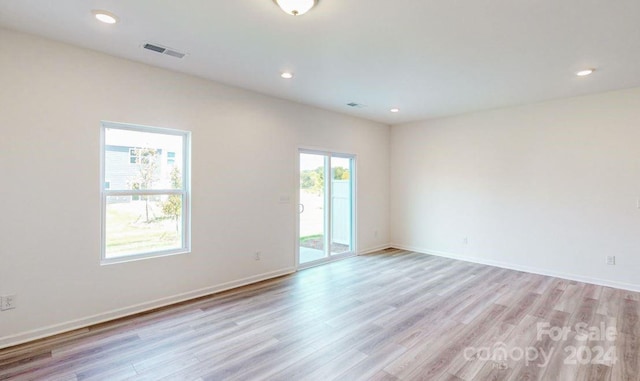 spare room with plenty of natural light and light hardwood / wood-style floors