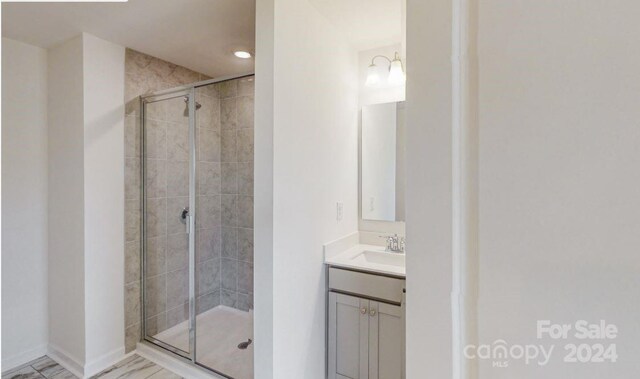 bathroom featuring a notable chandelier, vanity, and walk in shower