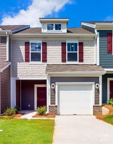 view of front of home featuring a front lawn and a garage