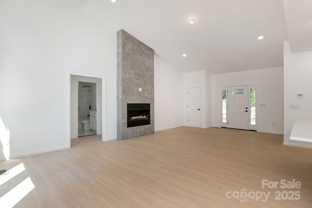 654 Hollybrook Dr, Flat Rock, NC 28731 - unfurnished living room featuring high vaulted ceiling, a tile fireplace, light wood-type flooring, and recessed lighting