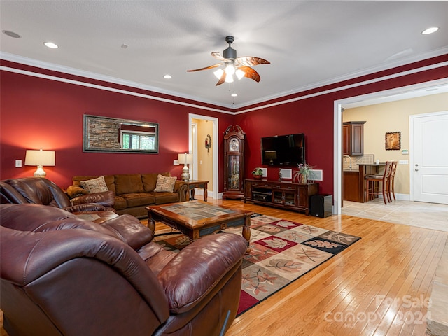 living room featuring ceiling fan, ornamental molding, and light tile patterned floors