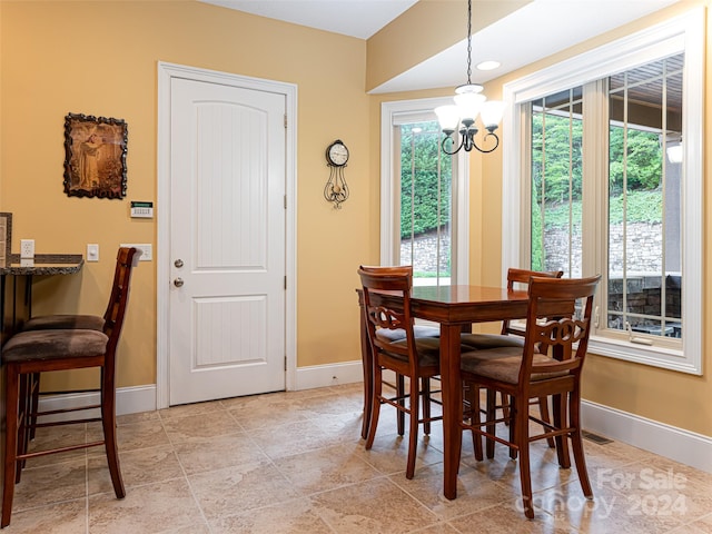 dining area with a notable chandelier and light tile patterned flooring