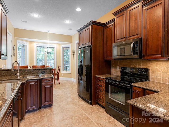 kitchen with decorative backsplash, hanging light fixtures, black appliances, and light tile patterned floors