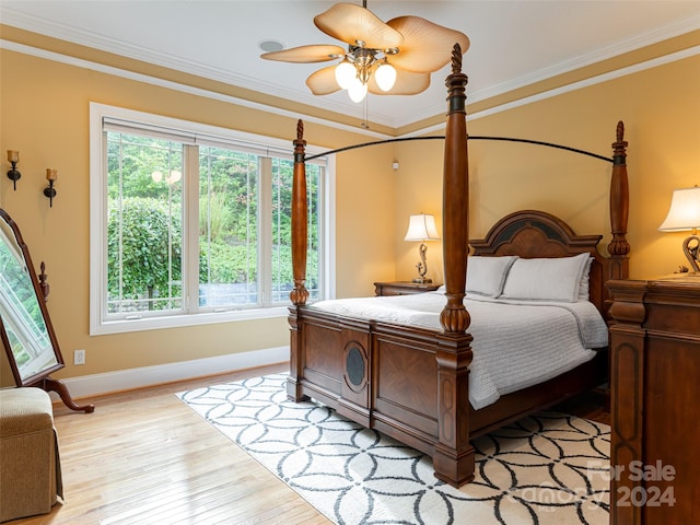 bedroom with light wood-type flooring, ceiling fan, and ornamental molding