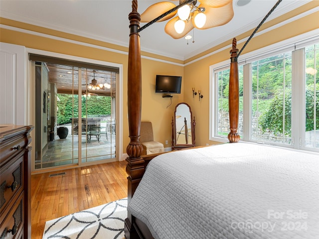 bedroom featuring multiple windows, access to outside, hardwood / wood-style flooring, and crown molding