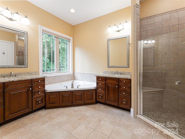 bathroom with tile patterned floors, separate shower and tub, and double sink vanity