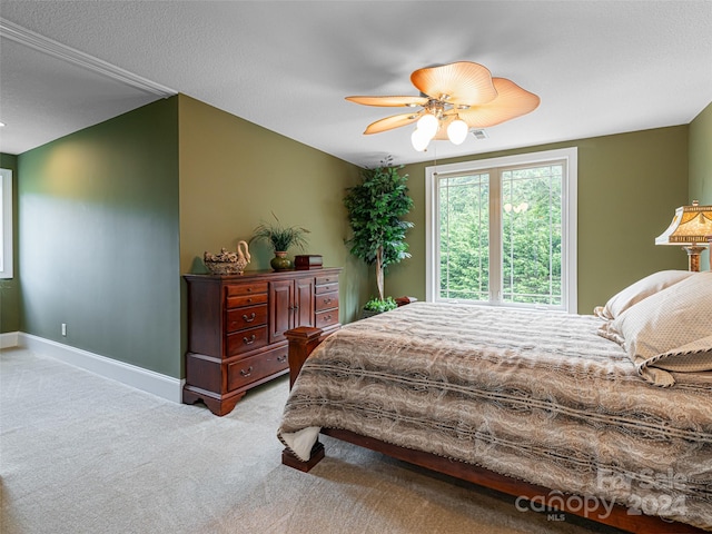 carpeted bedroom with a textured ceiling and ceiling fan