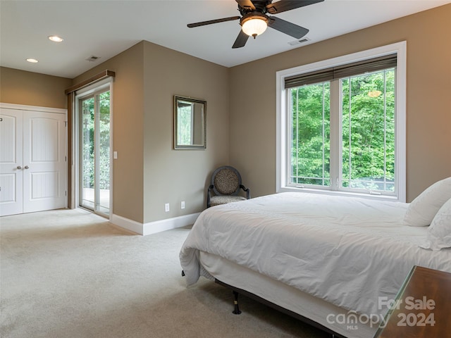 bedroom featuring multiple windows, ceiling fan, access to outside, and light colored carpet