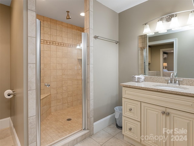 bathroom featuring vanity, walk in shower, and tile patterned flooring