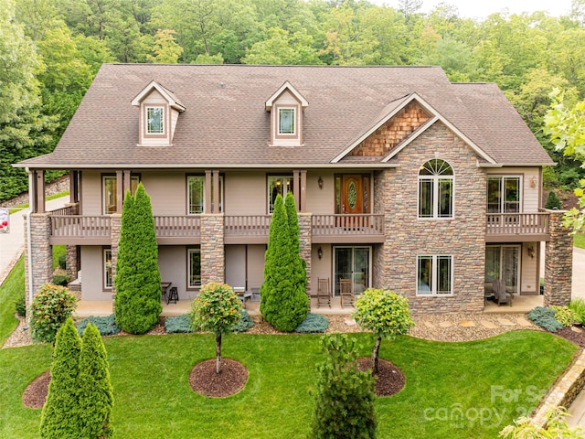 view of front of house with a balcony, a patio area, and a front lawn