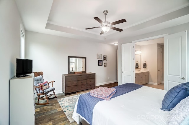 bedroom with dark hardwood / wood-style flooring, a raised ceiling, ceiling fan, and ensuite bathroom