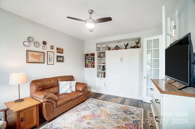 living room with dark wood-type flooring and ceiling fan