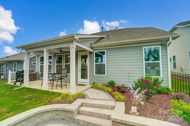 back of house featuring a patio, ceiling fan, and a lawn