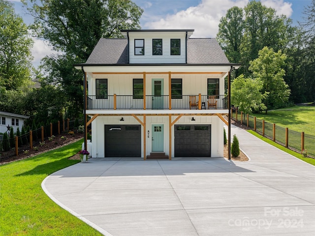 view of front of house featuring covered porch, a garage, and a front yard