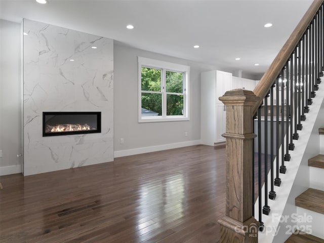 unfurnished living room with recessed lighting, dark wood finished floors, baseboards, and a premium fireplace