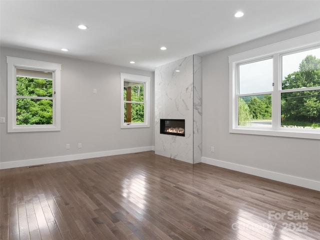 unfurnished living room featuring dark wood-type flooring, recessed lighting, and plenty of natural light