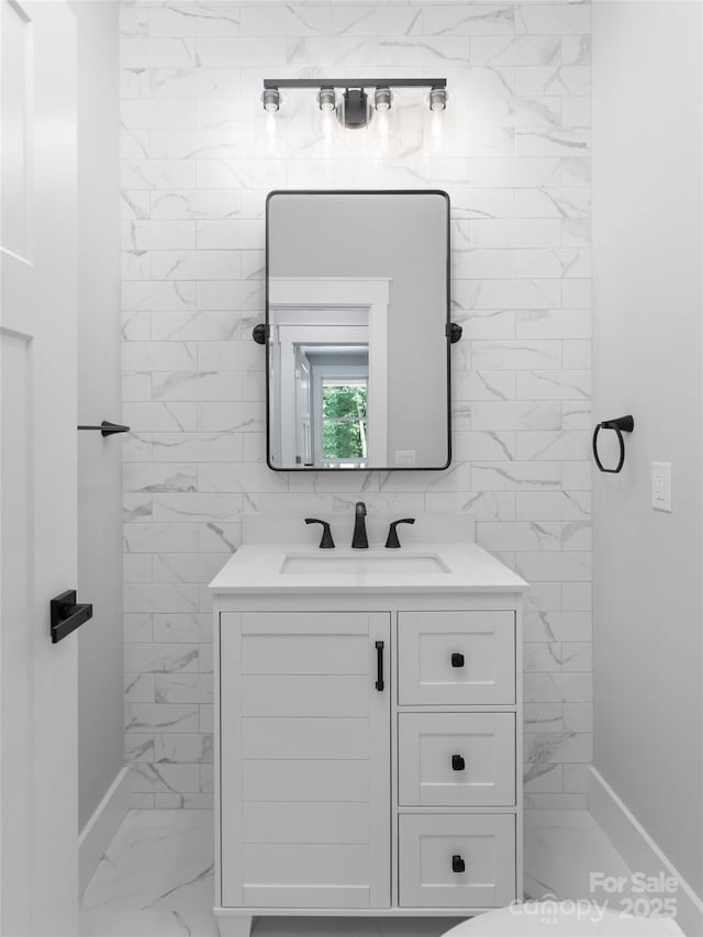 bathroom with marble finish floor and vanity