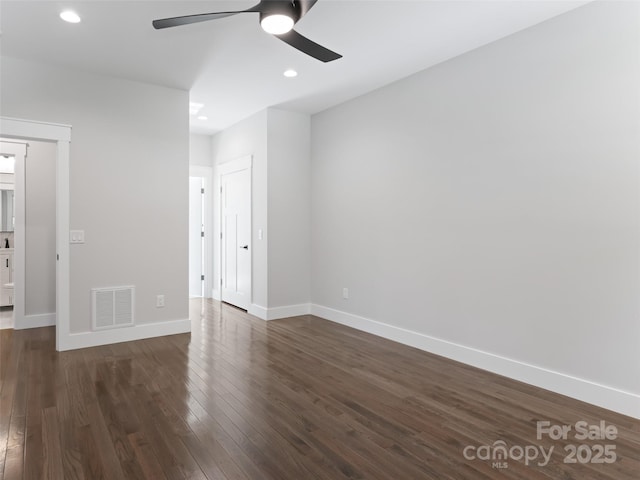 unfurnished bedroom with dark wood-style flooring, visible vents, and baseboards