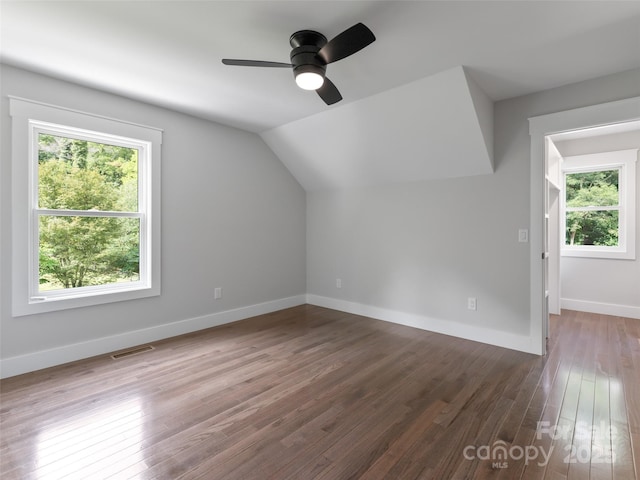 additional living space featuring baseboards, visible vents, ceiling fan, wood finished floors, and vaulted ceiling