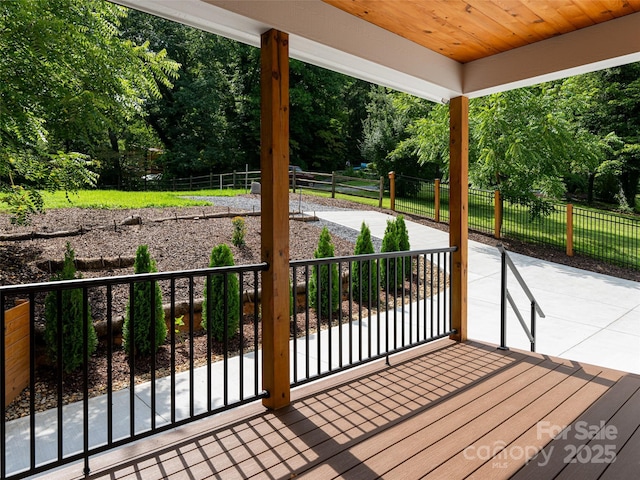 wooden deck with a patio area and a fenced backyard