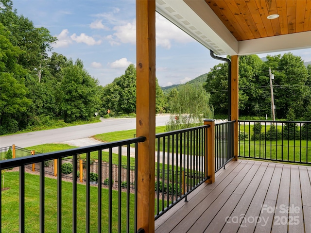 wooden deck with a lawn and fence