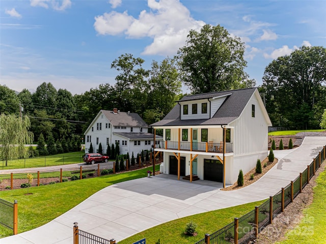 view of front of house with a garage, a front yard, driveway, and fence private yard