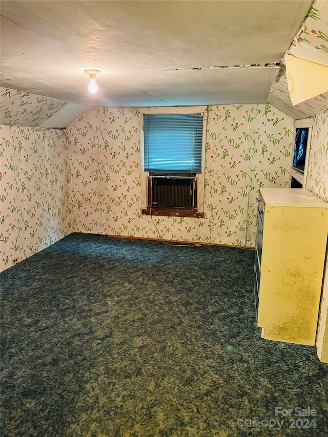 additional living space with lofted ceiling and dark colored carpet